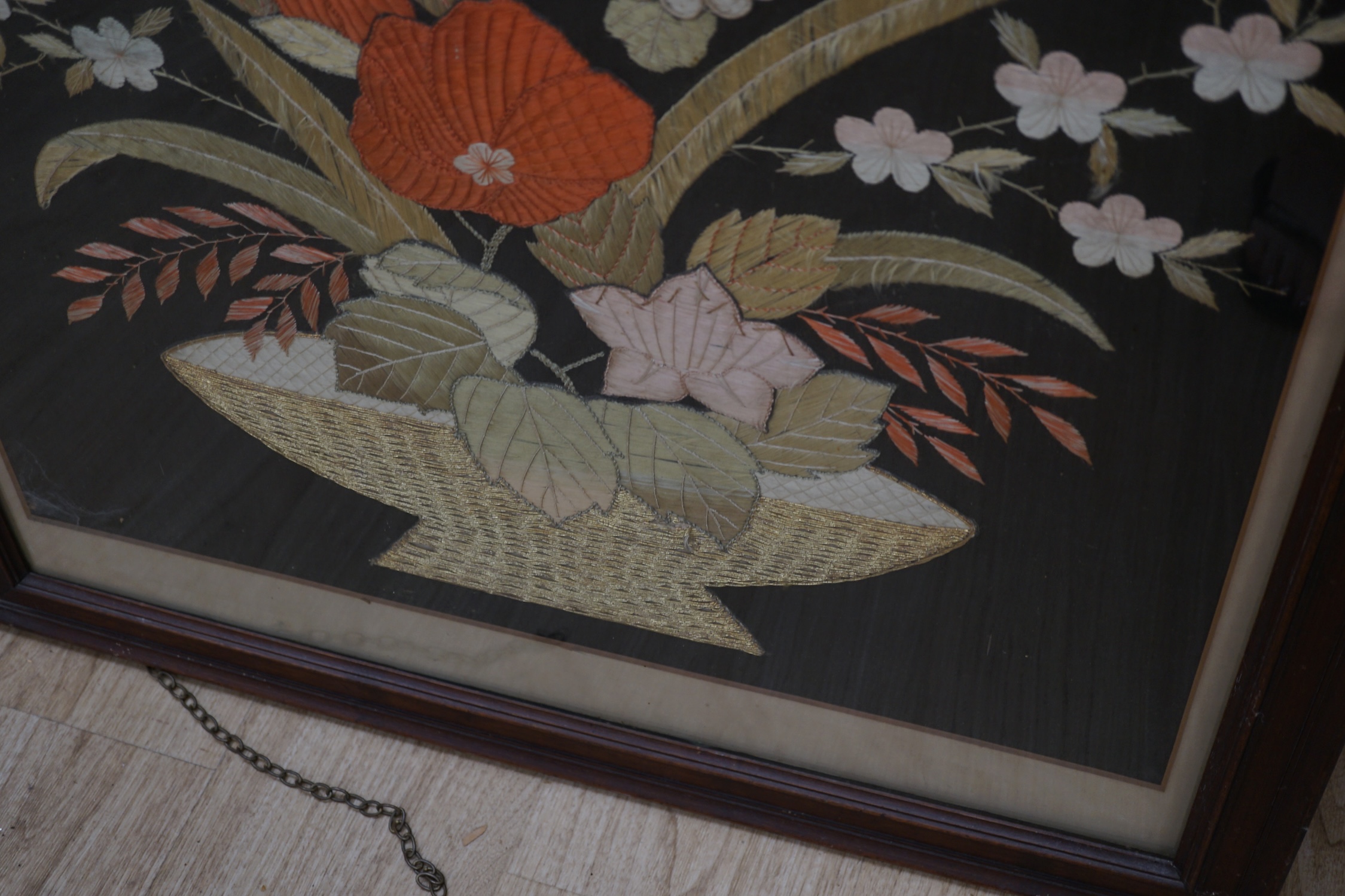 A 1900 to 1920’s Japanese silk embroidery of birds in flight and flowers on a grey background, 131cm high, 52cm wide, together with a Japanese silk and metallic thread still life embroidery on black background, with couc